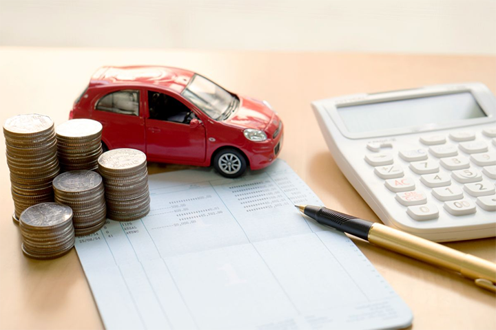 Coins, toy car and calculator on a desk