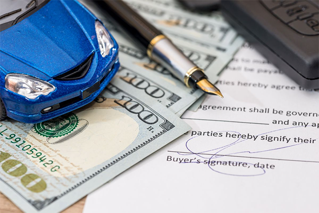 toy car, cash, pen and a document on a desk