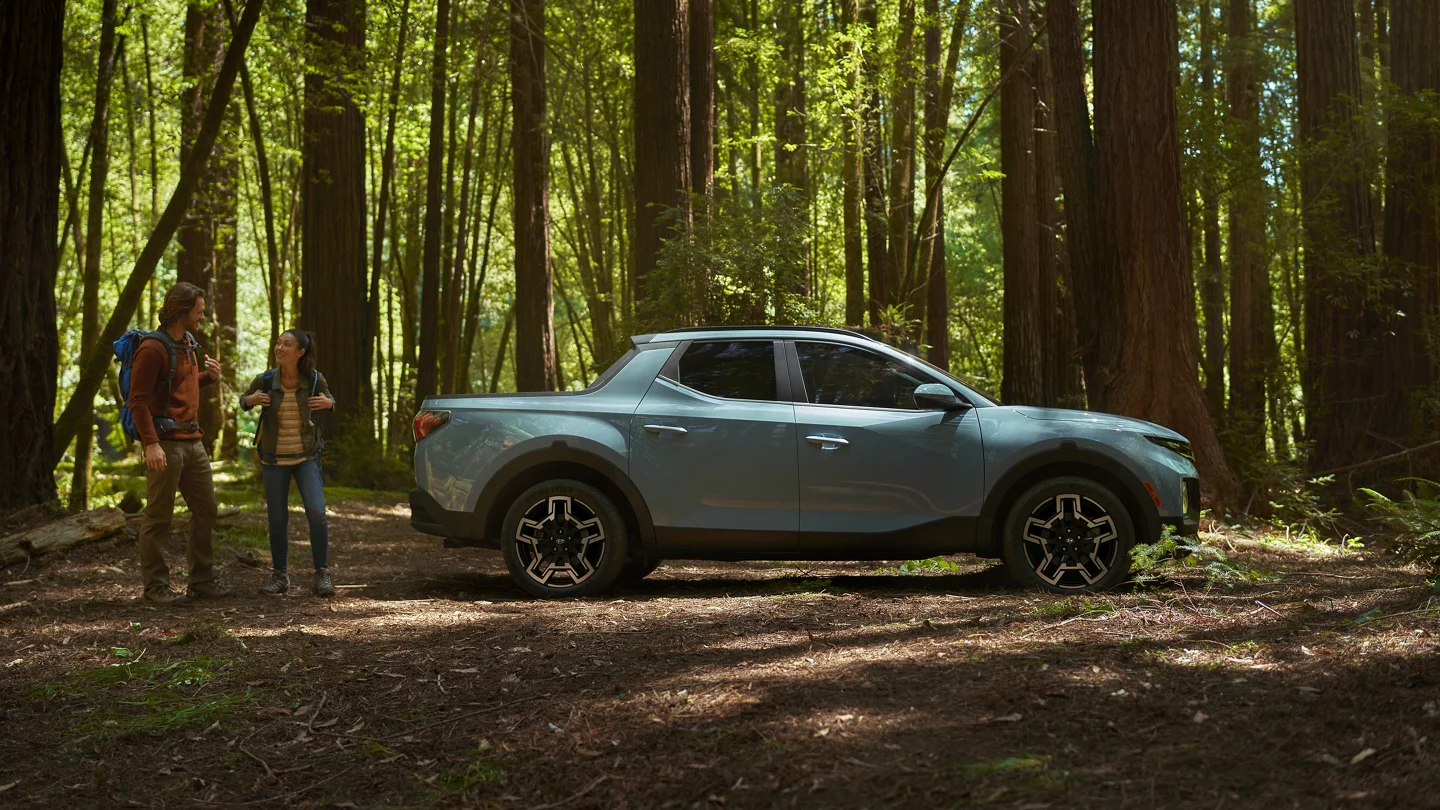 Blue Stone 2026 Hyundai Santa Cruz in a forest with a couple