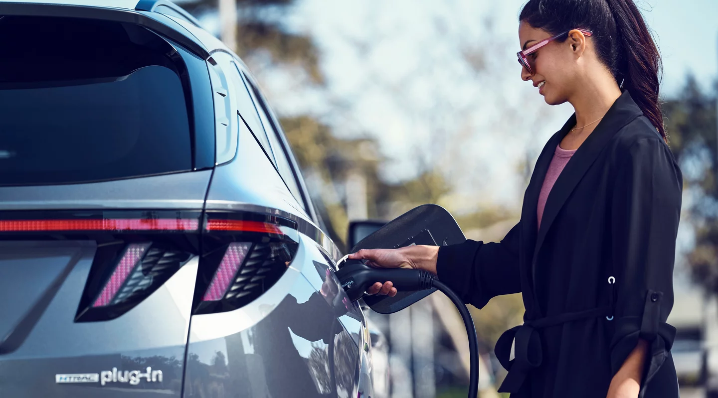 Woman charging a Hyundai Tucson PHEV